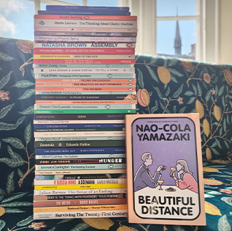 Slim books pilled on a sofa